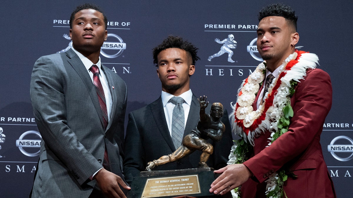 Heisman Trophy finalists, from left, Dwayne Haskins, from Ohio State; Kyler Murray, from Oklahoma; and Tua Tagovailoa, from Alabama, pose with the trophy during a media event Saturday, Dec. 8, 2018, in New York. (AP Photo/Craig Ruttle)