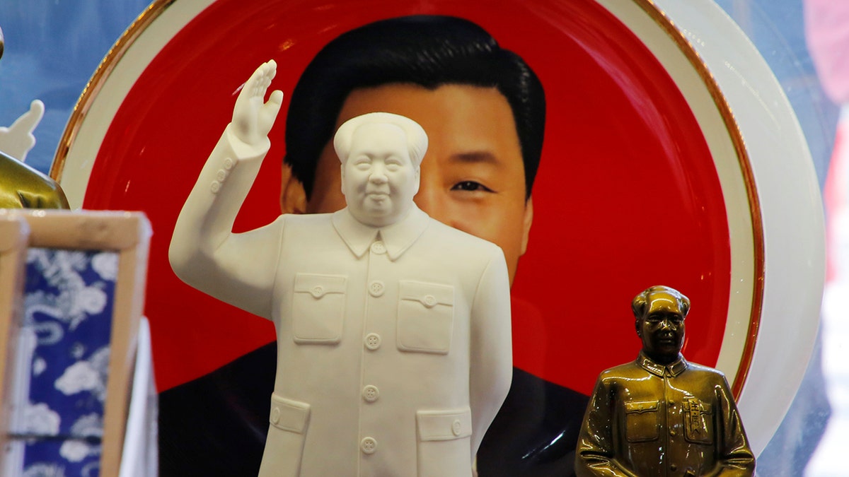 Sculptures of the late Chinese Chairman Mao Zedong are placed in front of a souvenir plate featuring a portrait of Chinese President Xi Jinping at a shop next to Tiananmen Square in Beijing, China, March 1, 2018. REUTERS/Jason Lee - RC19877D4F20