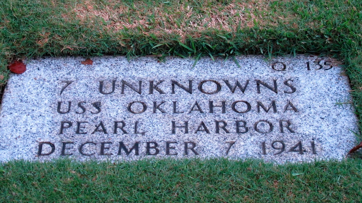 The National Memorial Cemetery of the Pacific in Honolulu displays a gravestone identifying it as the resting place of seven unknown people from the USS Oklahoma who died in Japanese bombing of Pearl Harbor. 