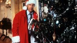 Chevy Chase hides behind the tree in a scene from the film 'Christmas Vacation', 1989. (Photo by Warner Brothers/Getty Images)