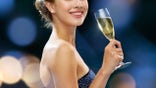 A woman is shown with a glass of Chamagne in this glamorous image.