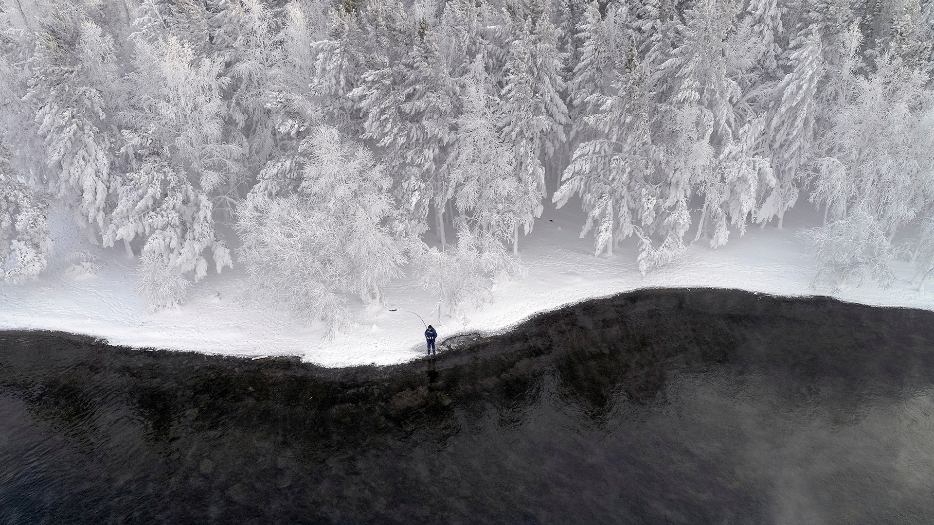 A man fishes on a bank of the Yenisei River covered with snow and hoarfrost with the air temperature at about -16 degrees Celsius outside the Siberian city of Krasnoyarsk, Russia, Dec. 10, 2018. REUTERS/Ilya Naymushin 