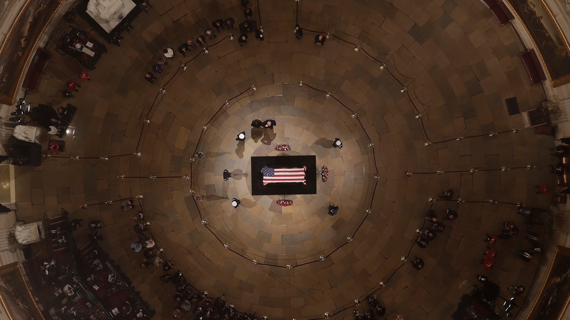 President Trump salutes as he and first lady Melania Trump pay their respects as Former President George H. W. Bush lies in state in the U.S. Capitol Rotunda in Washington, Dec. 3, 2018.