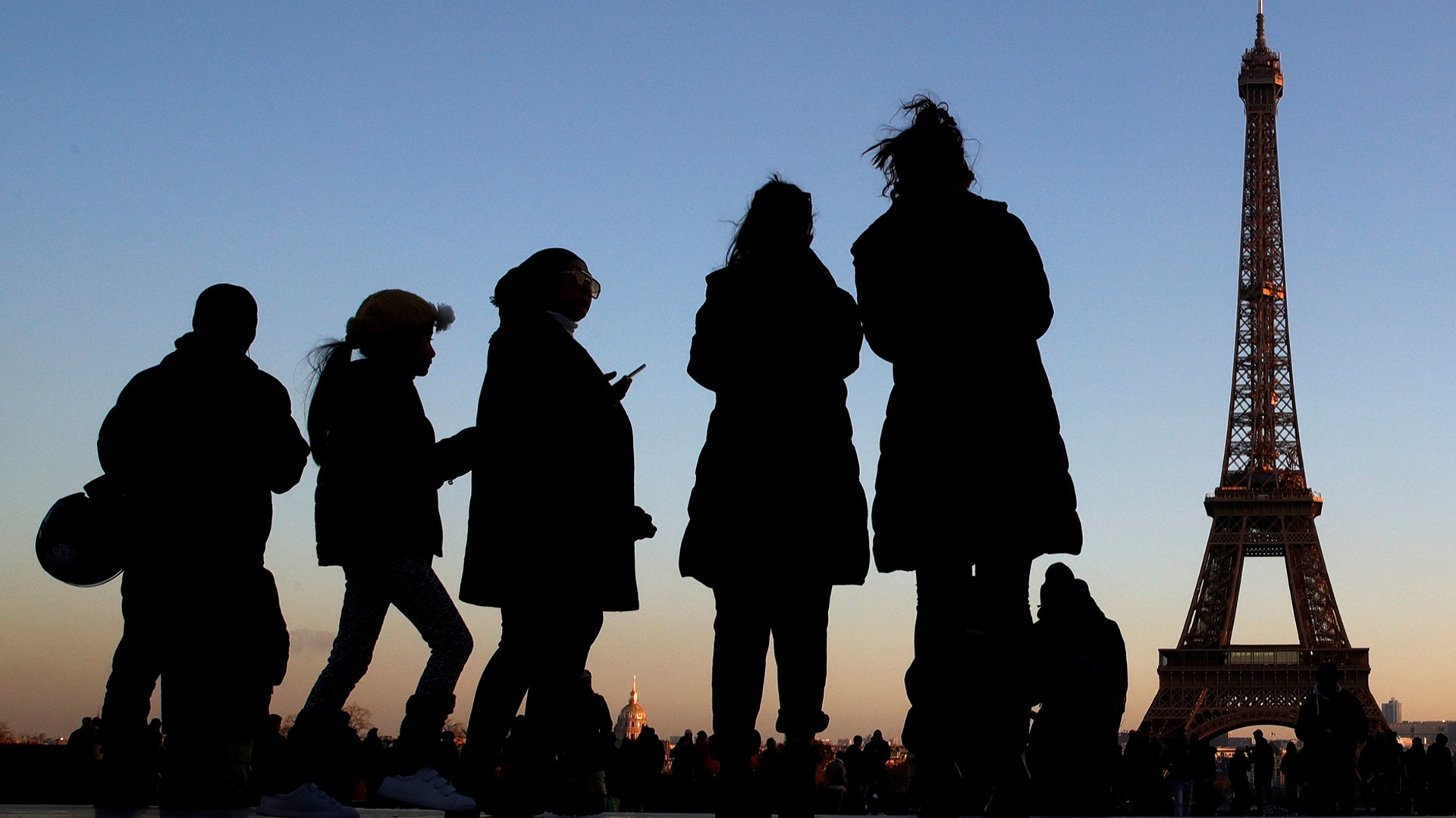 People stand at the Trocadero square near the Eiffel Tower in Paris, France, Dec. 12, 2018. 