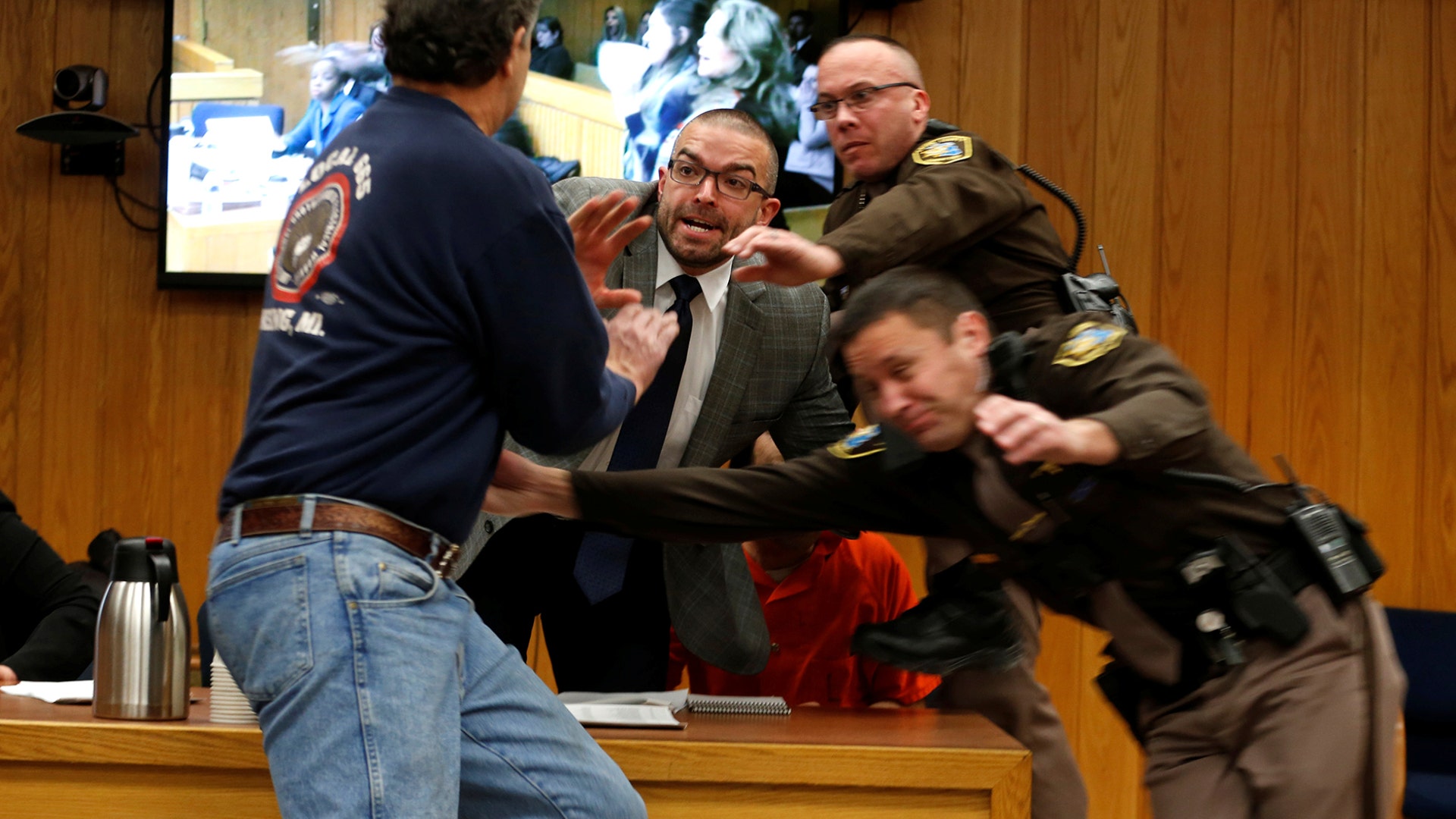 Randall Margraves lunges at Larry Nassar,(wearing orange) a former team USA Gymnastics doctor who pleaded guilty in November 2017 to sexual assault charges, during victim statements of his sentencing in the Eaton County Circuit Court in Charlotte, Michigan, February 2, 2018.