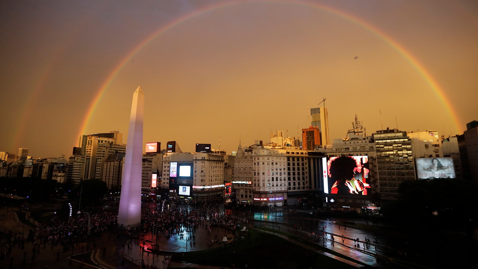 A double rainbow arches over downtown at the Obelisk where River Plate soccer fans celebrate their team's defeating Boca Juniors 3-1 and the clenching of the Copa Libertadores championship title, in Buenos Aires, Argentina, Dec. 9, 2018.  