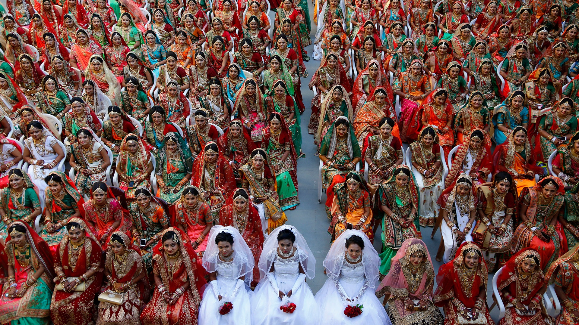 Indian brides sit together for a group photograph during a mass wedding in Surat, India, Dec. 23, 2018. 