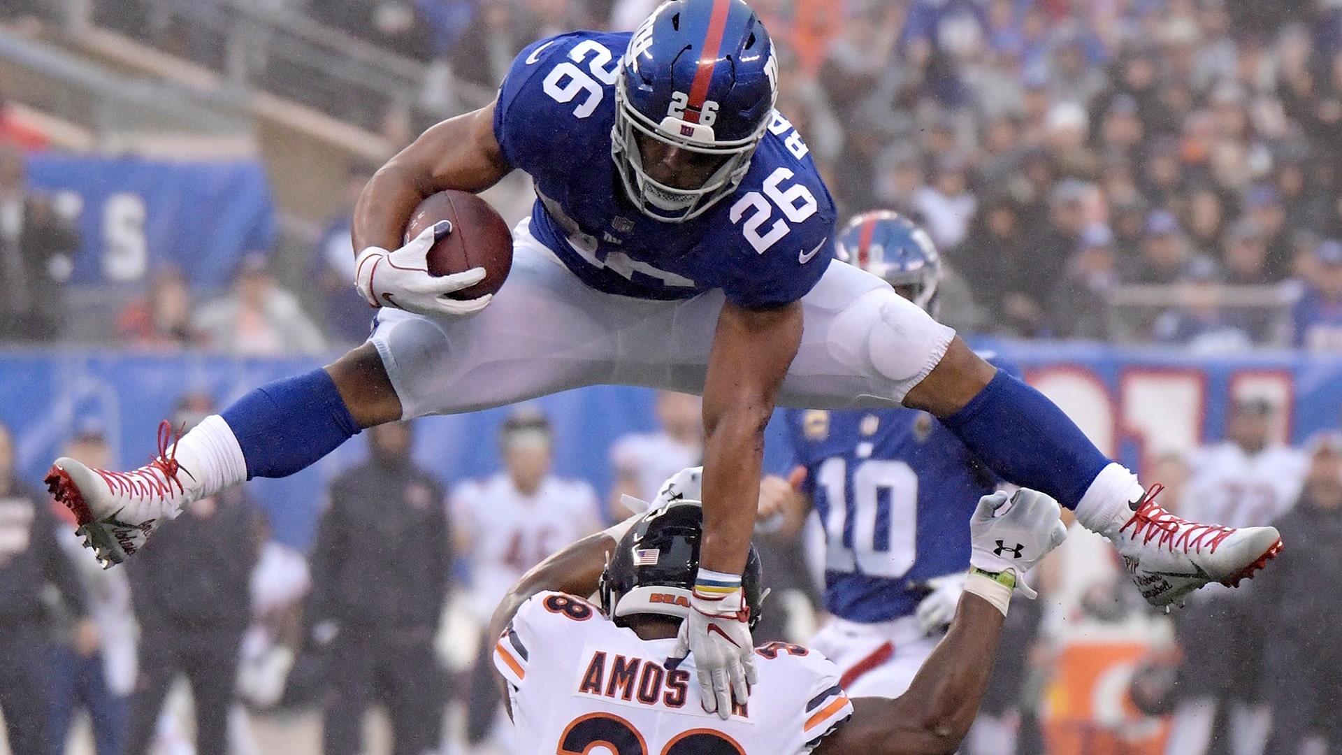 New York Giants running back Saquon Barkley leaps over Chicago Bears strong safety Adrian Amos during an NFL football game in East Rutherford, Dec. 2, 2018. 