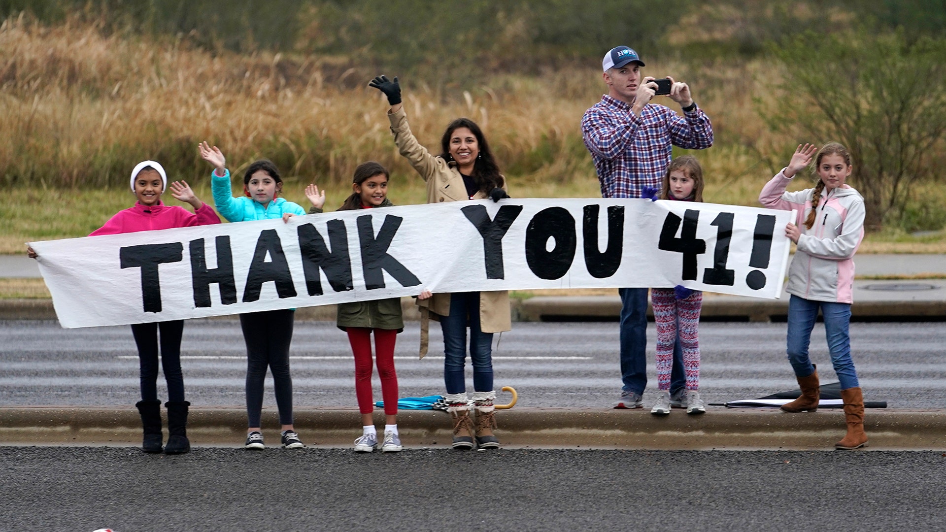 People pay their respects as the train carrying the casket of former President George H.W. Bush passes along the route from Spring to College Station, Texas, Dec. 6, 2018. 