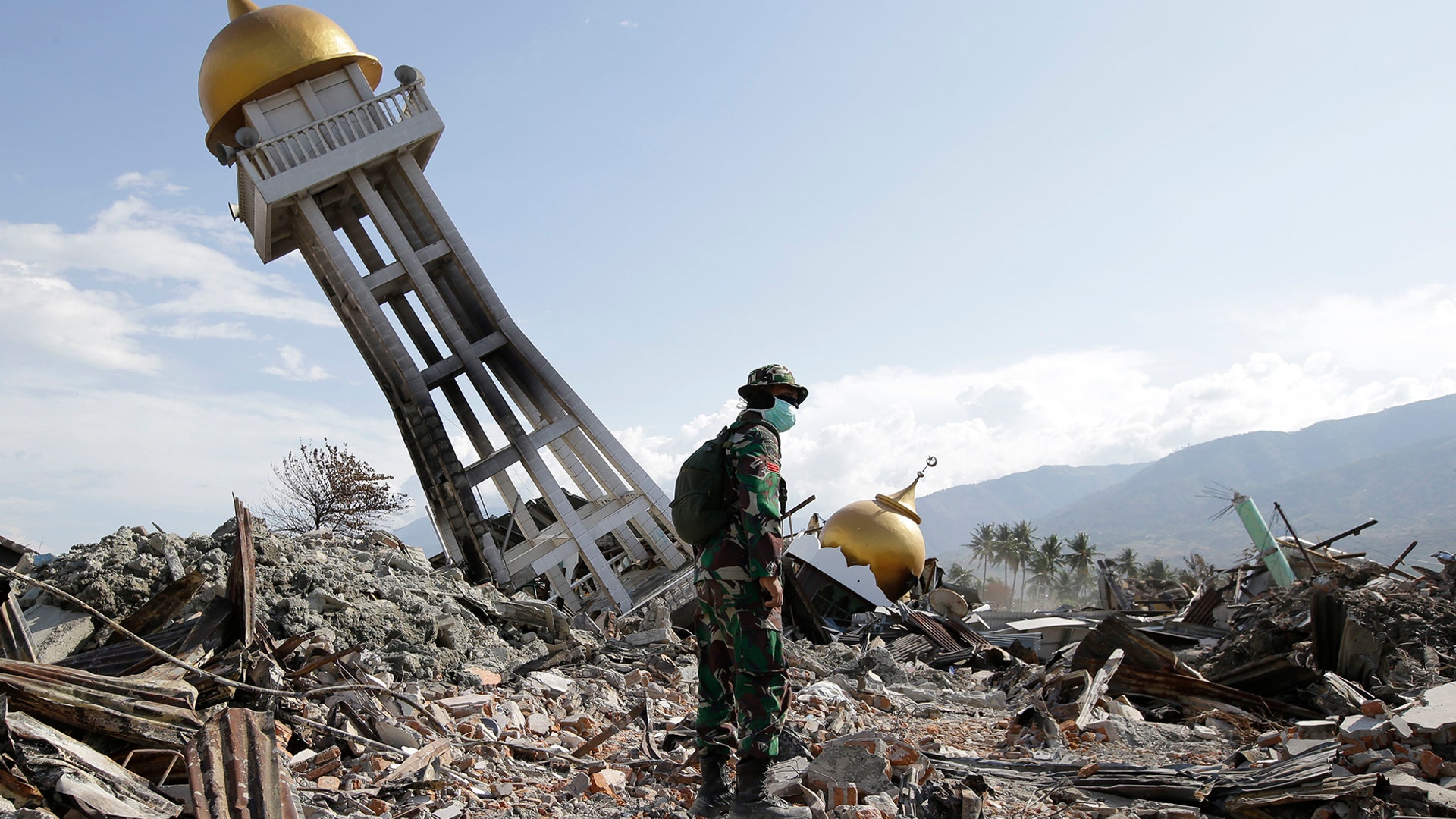 An Indonesian trooper stands beside a toppled mosque in the earthquake-hit Balaroa neighborhood in Palu, Central Sulawesi, Indonesia, October 6, 2018. 