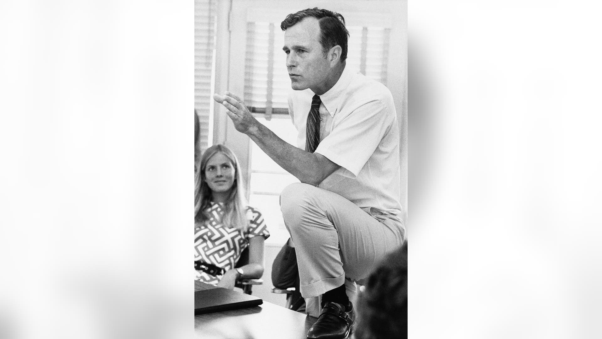 In this Oct. 9, 1970 file photo, Rep. George H.W. Bush, R-Texas, talks with a group of young people at a rally in Houston, Texas. 