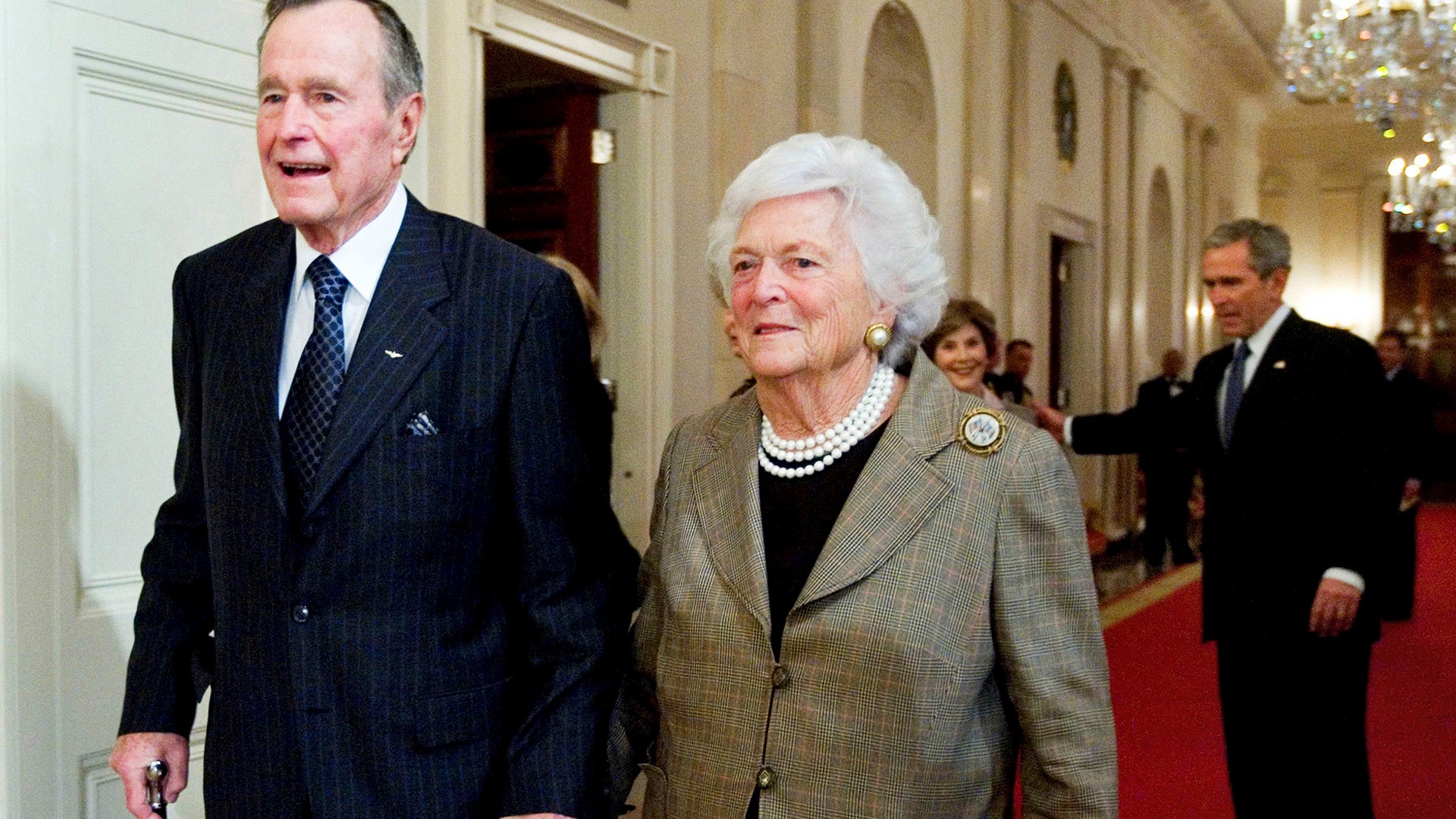 In this Jan. 7, 2009, file photo, former President George H. W. Bush, left, walks with his wife, former first lady Barbara Bush, followed by their son, President George W. Bush, and his wife first lady Laura Bush, to a reception in honor of the Points of Light Institute, in the East Room at the White House in Washington.