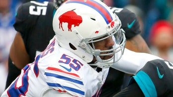 Buffalo Bills' Jerry Hughes gets his helmet stuck on teammate's jersey