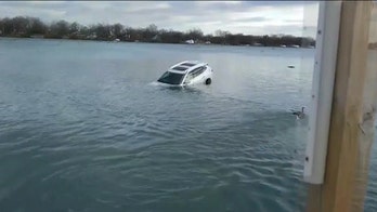 Dramatic video shows Michigan police officer using kayak to rescue woman from sinking car