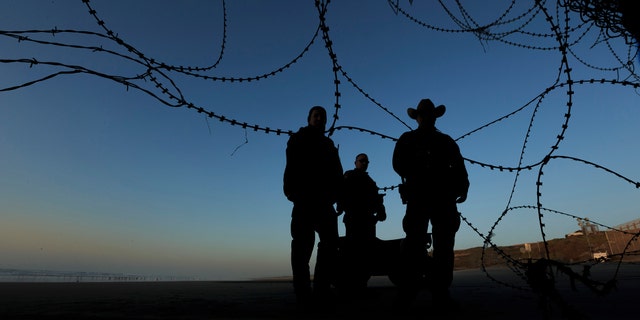 Border patrol officers stand at the beach on the U.S. side of the fence between San Diego and Tijuana, Mexico, Monday, Dec. 24, 2018. Discouraged by the long wait to apply for asylum through official ports of entry, many Central American migrants from recent caravans are choosing to cross the U.S. border wall and hand themselves in to border patrol agents. (AP Photo/Daniel Ochoa de Olza)
