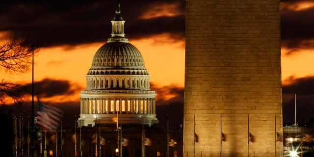 The U.S. Capitol dome is seen past the base of the Washington Monument just before sunrise in Washington, Saturday, Dec. 22, 2018. (AP Photo/Carolyn Kaster)
