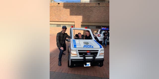 Aidan Riley, pictured with his police officer father and David Vogel, regional director of Magic Wheelchair, received his customized car on Wednesday.