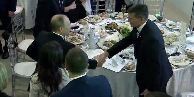 In this image made from a video taken on Dec. 10, 2015 and made available on Tuesday, Feb. 14, 2017, US President Donald Trump's former National Security Advisor Michael Flynn, right, shakes hands with Russian President Vladimir Putin, in Moscow.
