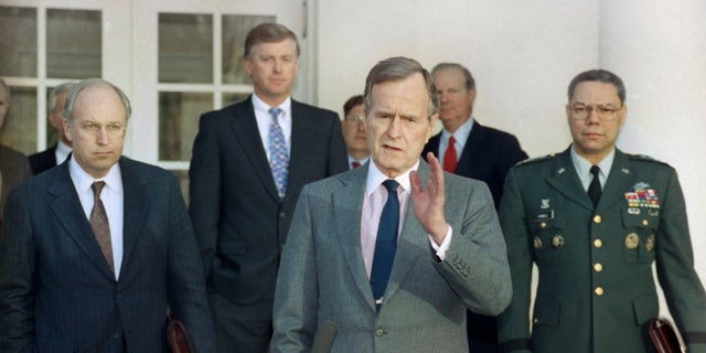 FILE - In this Feb. 11, 1991, file photo, President George H.W. Bush talks to reporters in the Rose Garden of the White House after meeting with top military advisors to discuss the Persian Gulf War. From left are, Defense Secretary Dick Cheney, Vice President Dan Quayle, White House Chief of Staff John Sununu, the president, Secretary of State James A. Baker III, and Joint Chiefs Chairman Gen. Colin Powell. Bush died at the age of 94 on Friday, Nov. 30, 2018, about eight months after the death of his wife, Barbara Bush.