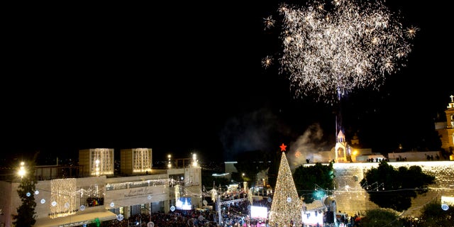 Palestinian Christians celebrate the lighting of a Christmas tree in Manger Square, outside the Church of the Nativity in the West Bank town of Bethlehem, Saturday, Dec. 1, 2018.(AP Photo/Majdi Mohammed)