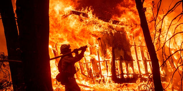 Flames from the Camp Fire tearing through a home in Magalia, Calif., in November 2018. (AP Photo/Noah Berger, File)