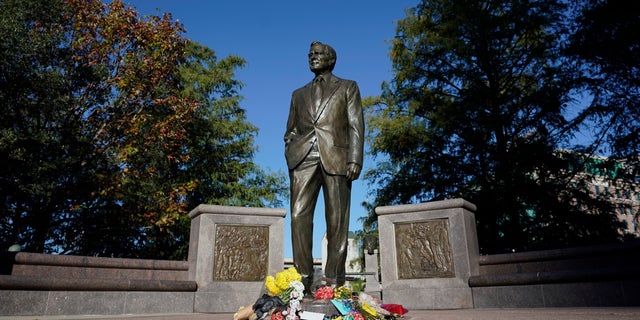 A makeshift memorial sits at the base of a statue of former President George H.W. Bush in downtown Houston.