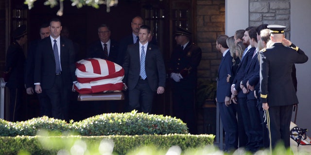 Members of the U.S. Secret Service carry the casket with former President George H. W. Bush to a hearse after a family service.