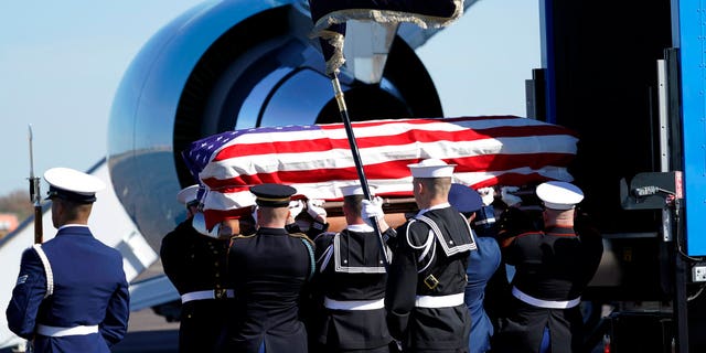 The flag-draped casket of former President George H.W. Bush is carried by a joint services military honor guard to Special Air Mission 41 at Ellington Field during a departure ceremony Monday, Dec. 3, 2018, in Houston.