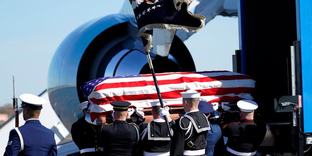 The flag-draped casket of former President George H.W. Bush is carried by a joint services military honor guard to Special Air Mission 41 at Ellington Field during a departure ceremony Monday, Dec. 3, 2018, in Houston.