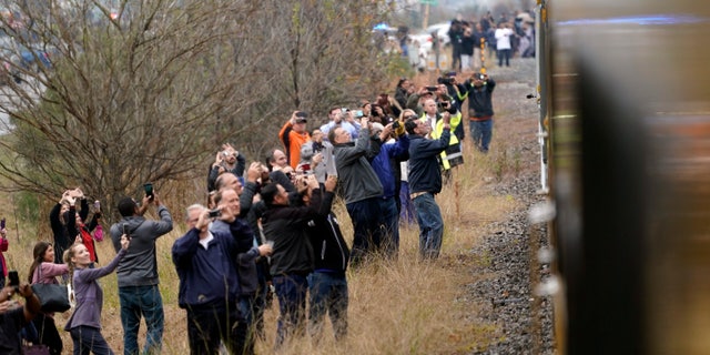 People paying their respects and take photos as the train carrying the casket of former President George H.W. Bush passes on Thursday. The train was making its way from Spring, Texas, to College Station.