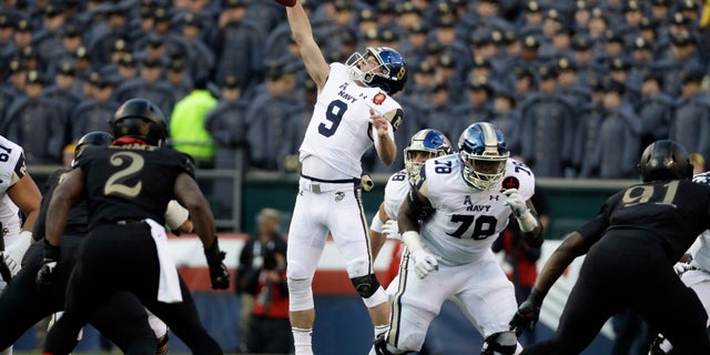 Navy's Zach Abey leaps for a high snap during the first half of an NCAA college football game against Army, Saturday, Dec. 8, 2018, in Philadelphia. (AP Photo/Matt Slocum)