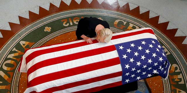 Cindy McCain, wife of the late Sen. John McCain, R-Ariz., rested her head on his casket during a memorial service at the Arizona Capitol.