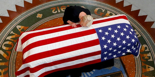 Cindy McCain, wife of the late Sen. John McCain, R-Ariz., rested her head on his casket during a memorial service at the Arizona Capitol.