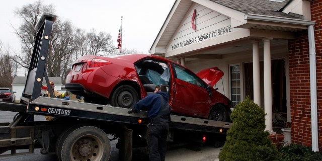 A car that crashed into the entrance of the Crossroads United Methodist Church is towed out of the doorway on Sunday, December 23, 2018 in Columbus, Ohio. A woman drove into the church during morning services, injuring several people. (Brooke LaValley/The Columbus Dispatch via AP)