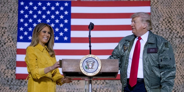 First lady Melania Trump, left, and President Donald Trump stand together on stage during a hanger rally at Al Asad Air Base, Iraq, Wednesday, Dec. 26, 2018. (Associated Press)