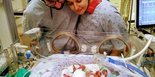 Parents Daniel Breyts and Jess Novac with their son, Rowan, who was given a slim chance of survival, but turned around against all odds.