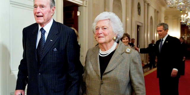 President George H. W. Bush and his wife Barbara Bush, followed by their son, President George W. Bush and his wife first lady Laura Bush, walking to a reception in the White House on Jan. 7, 2009.