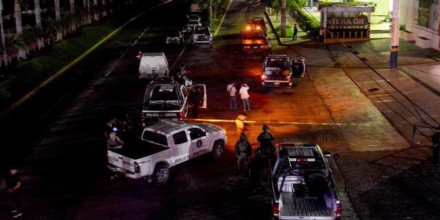 Policemen work at a crime scene after a colleague was killed in Acapulco on July 23, 2018. - Mexican President-elect Andres Manuel Lopez Obrador, who will take office on December 1, 2018 inherits a messy war on drug cartels from his predecessor Enrique Pena Nieto. Since Mexico deployed its army to fight drug trafficking in 2006 during the presidency of Felipe Calderon, the country has been engulfed in a wave of violence that has left more than 200,000 murders, 30,000 missing, as well as complaints against the heavily armed security forces for violations, extrajudicial executions and forced disappearances. 