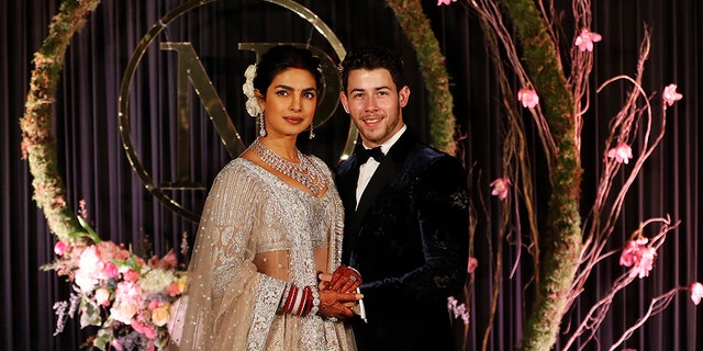 Bollywood actress Priyanka Chopra and musician Nick Jonas stand for photographs at their wedding reception in New Delhi, India, Tuesday, Dec. 4, 2018. (AP Photo/Altaf Qadri)
