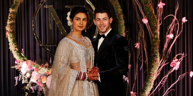 Bollywood actress Priyanka Chopra and musician Nick Jonas stand for photographs at their wedding reception in New Delhi, India, Tuesday, Dec. 4, 2018. (AP Photo/Altaf Qadri)