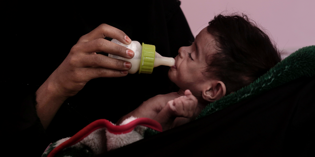 FILE - In this Feb. 13, 2018 file photo, Ahmed Rashid Mokbel, a severely malnourished 7-month-old Yemeni boy, is given formula by his mother at the Al-Sadaqa Hospital in Aden, Yemen. Oxfam, an international aid group, said Wednesday, Dec. 19, 2018, that more than half a million displaced people in war-torn Yemen face the "double threat" of famine and freezing temperatures as winter sets in. Oxfam said that some 530,000 displaced people are in mountainous areas, many living in makeshift shelters with no insulation or weatherproofing. (AP Photo/Nariman El-Mofty, File)