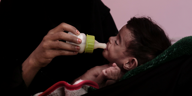 FILE - In this Feb. 13, 2018 file photo, Ahmed Rashid Mokbel, a severely malnourished 7-month-old Yemeni boy, is given formula by his mother at the Al-Sadaqa Hospital in Aden, Yemen. Oxfam, an international aid group, said Wednesday, Dec. 19, 2018, that more than half a million displaced people in war-torn Yemen face the "double threat" of famine and freezing temperatures as winter sets in. Oxfam said that some 530,000 displaced people are in mountainous areas, many living in makeshift shelters with no insulation or weatherproofing. (AP Photo/Nariman El-Mofty, File)