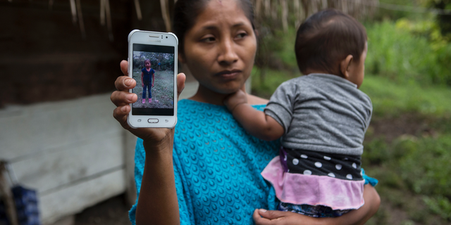 Claudia Maquin, 27, showed a photo of her daughter, Jakelin Amei Rosmery Caal Maquin in Raxruha, Guatemala, on Dec. 15, 2018. (AP Photo/Oliver de Ros)