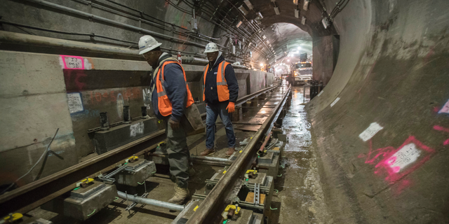 In this Nov. 29, 2018 photo, a construction crew works on the tracks of the East Side Access project beneath Grand Central Terminal in New York. The super-pricey railroad hub is taking shape, dogged by billion-dollar cost overruns and a decade of delays, but still impressive as an engineering marvel. (AP Photo/Mary Altaffer)