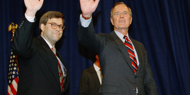 FILE - In this Nov. 26, 1991, file photo, President George H.W Bush, right, and William Barr wave after Barr was sworn in as the new Attorney General of the United States at a Justice Department ceremony in Washington. Barr, President Donald Trump’s pick for attorney general, once questioned the effectiveness of a border wall similar to the one the president now wants to construct. Barr was attorney general under President George H.W. Bush when he was asked in a 1992 interview if he supported a proposal from Republican challenger Pat Buchanan to erect a barrier of ditches and fences along the Mexican border to stem the flow of illegal immigrants. Barr described a side-to-side barrier as “overkill.” (AP Photo/Scott Applewhite, File)