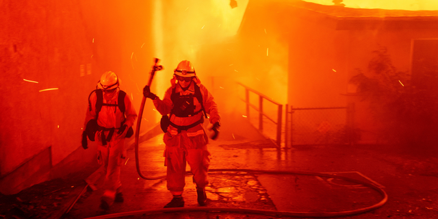 FILE - In this Thursday, Nov. 8, 2018 file photo, firefighters battle the Camp Fire as it tears through Paradise, Calif. A report on firefighter injuries in a deadly Northern California wildfire details harrowing conditions they faced and a few close calls with death. The report released Thursday, Dec. 13, 2018 by the California Department of Forestry and Fire Protection said the Camp Fire overtook three firefighters trying to set a backfire Nov. 8 to stop the blaze. (AP Photo/Noah Berger, File)