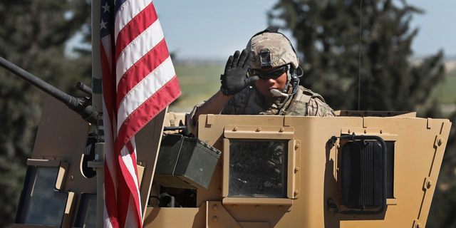 A U.S. soldier in an armored vehicle, at a road leading to the tense front line with Turkish-backed fighters, in Manbij town, northern Syria, in 2018. (AP Photo/Hussein Malla, File)