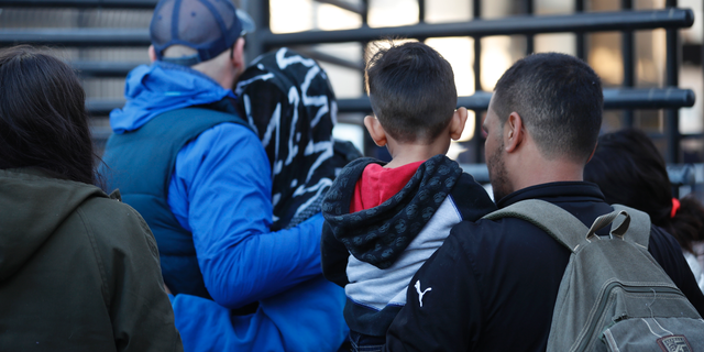 Honduran asylum seekers enter the U.S. at San Diego's Otay Mesa port of entry, as seen from Tijuana, Mexico, Tuesday, Dec. 18, 2018. Six Honduran asylum seekers spent a chilly night camped out on a tiny patch of U.S. soil at a San Diego border crossing seeking to have their claims processed. (AP Photo/Moises Castillo)
