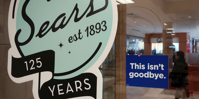 In this Nov. 2, 2018 photo, a sign in the window at Sears promises that "This isn't goodbye," at the Livingston Mall in Livingston, N.J. Sears is closing 80 more stores as it teeters on the brink of liquidation. The 130-year old retailer set a deadline of Friday, Dec. 28, 2018 for bids for its remaining stores to avert closing down completely.  (AP Photo/Ted Shaffrey)
