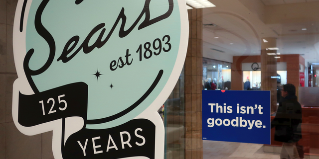In this Nov. 2, 2018 photo, a sign in the window at Sears promises that "This isn't goodbye," at the Livingston Mall in Livingston, N.J. Sears is closing 80 more stores as it teeters on the brink of liquidation. The 130-year old retailer set a deadline of Friday, Dec. 28, 2018 for bids for its remaining stores to avert closing down completely. (AP Photo/Ted Shaffrey)